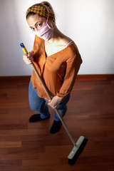casalinga spazza la casa con la mascherina protettiva facciale 