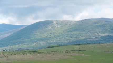 The top of the mountain valley. Mountains before the rain, gray sky covered with clouds. Mountain landscape.