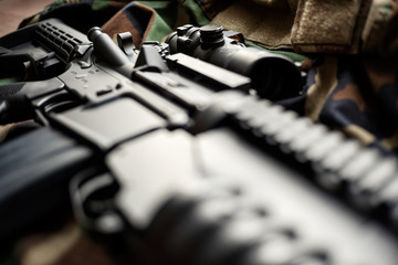 Military still life: AR15 assault rifle with optical sight and US Army uniform, very shallow depth of field
