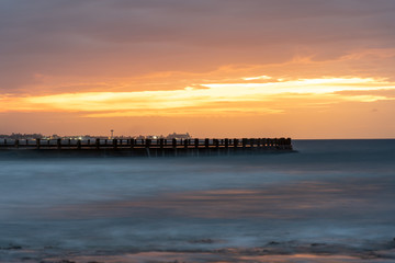 Fototapeta premium Groyne with water falling in the evening light on a coast in Havana. Cuba.
