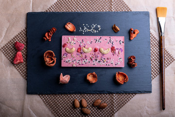 pink chocolate in assortment with hazelnuts rose petals cashew nuts