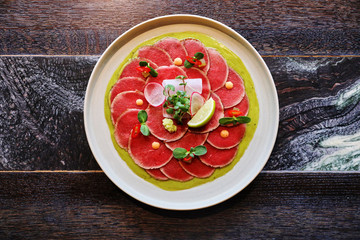 tuna carpaccio with Parmesan cheese, on dark background