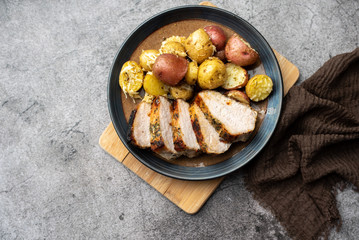 Roasted pork with spices and Parmesan roasted baby potatoes. Close up on a plate. 