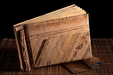 Stillleben: Buch auf Holzmatte.