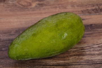 Green tasty mango over wooden background