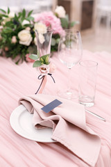 Luxurious wedding table decoration for reception of guests with stylish napkins, cute natural flower