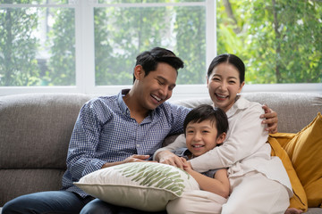 portrait of happy Asian family spending time together on sofa in living room. family and home...