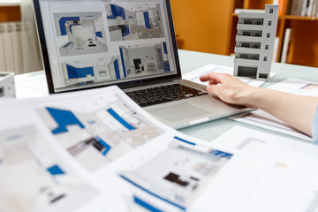 Interior designer working with a kitchen visual renderings in a design bureau.