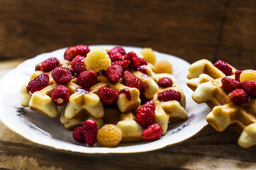 Homemade waffles with berries wooden background. Delicious, nutritious, fantastic breakfast or dessert. Soft focus