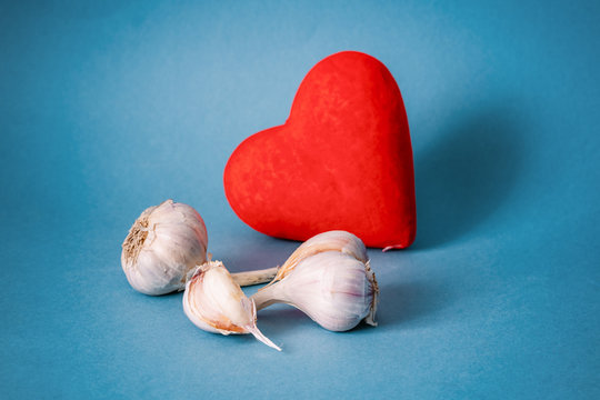 heads of garlic next to a heart on a blue background