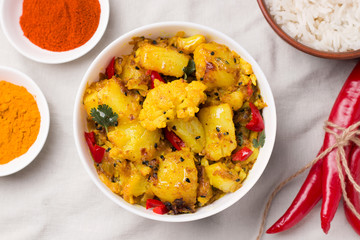 Indian traditional cuisine. Gobi aloo is a vegetarian dish of cauliflower and potato next to the ingredients.