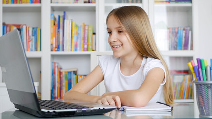 Kid Using Laptop Studying in Video Conferencing, Child Learning, Writing in Library, Schoolgirl Chatting with Teacher from Home in Coronavirus Pandemic Crisis, Children Homeschooling, Online Education