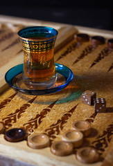Board games in backgammon, tawla, shesh-besh, kosh. Glass cup for Armudu tea and details of the board and checkers. The ancient game of the East and Asia. Relax and have fun with your friends.