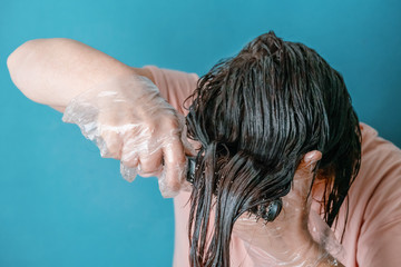 Naklejka premium gloved woman combing dyed hair