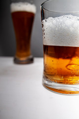 Closeup of pouring gold beer two on grey background for concept design. Summer concept.