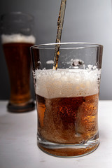 Closeup of pouring gold beer two on grey background for concept design. Summer concept.