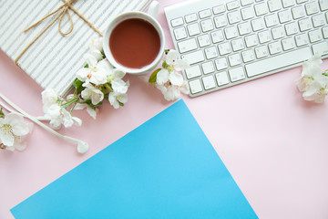 blue office desk background with smartphone with blank screen mockup, laptop computer, cup of coffee and supplies. Top view with copy space, flat lay.