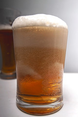 Closeup of pouring gold beer two on grey background for concept design. Summer concept.