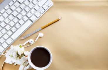 golden office desk background with smartphone with blank screen mockup, laptop computer, cup of coffee and supplies. Top view with copy space, flat lay.