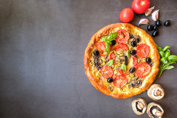  Homemade vegetarian pizza with mushrooms, olives,tomatoes, Basil and cheese on a dark background. Concept-healthy food. Top view. Copy space.