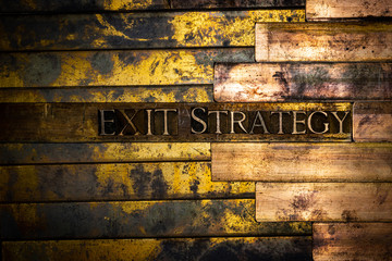 Photo of real authentic typeset letters forming Exit Strategy text on vintage textured grunge...
