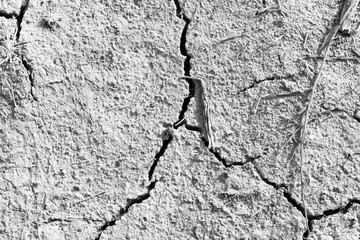 Dried and Cracked ground. Dry soil in arid areas. Cracks in the ground. Drought concept. Black and white photography. View from above. Closeup