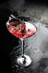 A splash in a beautiful cocktail glass with cosmopolitan