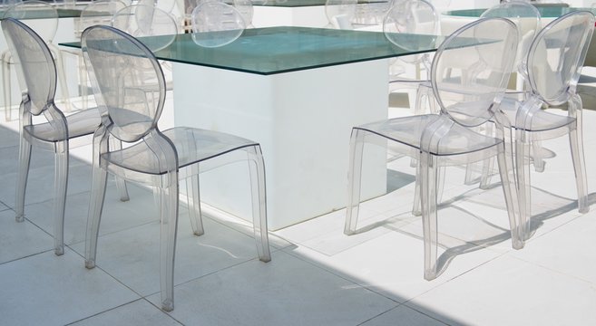 Glass tables and glass chairs in the interior. Futuristic design. Design restaurant, cafe. Minimalistic design. Chairs from transparent organic glass.