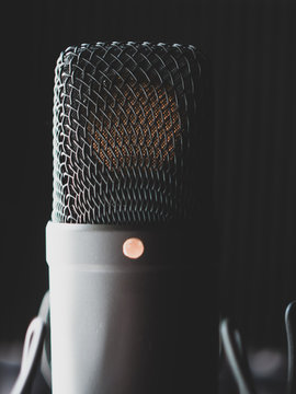 black metal condenser microphone in a recording studio on the background of an acoustic paralon pyramid