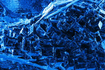 Ice carved pattern, blue backlight, dark background, texture.