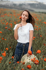 Romantic girl at sunset in poppy field - 345997396
