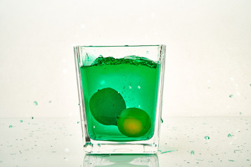 glass of green cocktail with lemons
