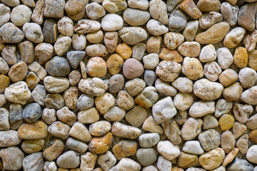 Horizontal color image with a front view of a texture of a wall made of sea stones