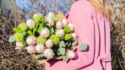 Elegant woman holding beautiful and exotic flower buquet in hands. Ice cream tulips bouquet close-up shot. Floral theme.