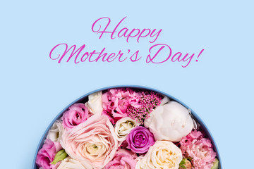 Happy mother's day picture. Blue background with hat box and flowers.