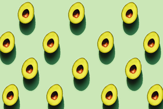 Half of avocados in sunlight on a green neon background. - Powered by Adobe