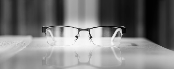 Okulary wyizolowane na tle książek. Okulary leżąna stole © Michal45
