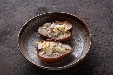 Baked pears with cottage cheese and honey decorated with almond slices.