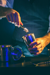 Bartender adding ice into cocktail shaker