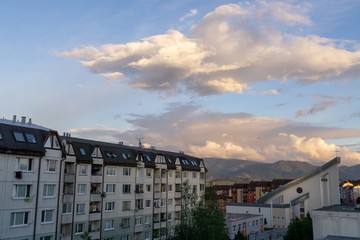 Sunrise and sunset, beautiful clouds over the meadow, hills and buildings in the town. Slovakia