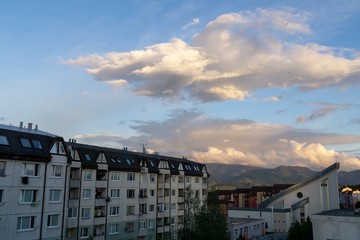Sunrise and sunset, beautiful clouds over the meadow, hills and buildings in the town. Slovakia