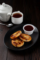 Traditional russian cottage cheese fritters with berries jam