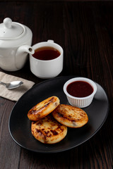 Traditional russian cottage cheese fritters with berries jam