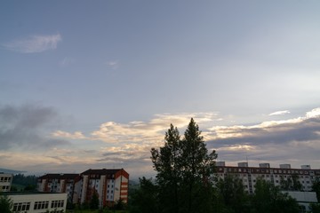 Sunrise and sunset, beautiful clouds over the meadow, hills and buildings in the town. Slovakia