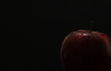 Dark red apple on black background