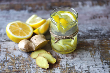 Selective focus. Ginger lemon drink. Ginger water with lemon. Fresh ginger and lemon. Immune enhancing vitamin tea with lemon and ginger.