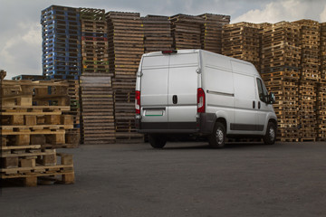 commercial freight van on the background of a pallet for packing goods © Artem