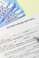 Registration and signing of the housing rent agreement. Russian text "the lease of the apartment," ruble bills for payment handle