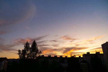 Sunrise and sunset, beautiful clouds over the meadow, hills and buildings in the town. Slovakia