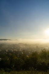 Fototapeta premium Sunrise and sunset, beautiful clouds over the meadow, hills and buildings in the town. Slovakia